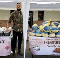 a man standing in front of a tent with bags of food